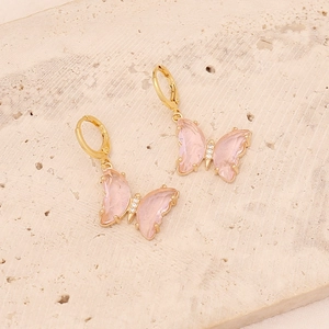 Detail of 18K gold butterfly earrings with pink resin wings and sparkling white zircon stones