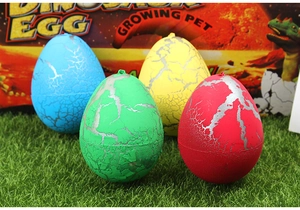 Four colorful hatching dinosaur eggs with silver cracks on green artificial grass