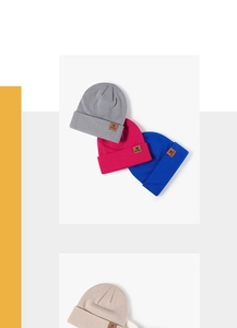 Detail of multi-color knitted beanies with premium leather brand patch and soft texture
