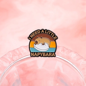 Cute Capybara enamel pin featuring a sleeping animal design and NAPYBARA text badge