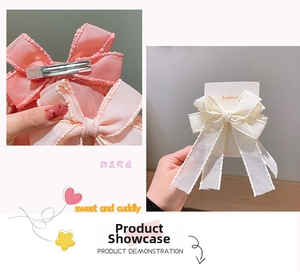 Macro detail of pink and white bow hair clips with silver metal duckbill clips