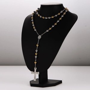 Religious rosary necklace with gold and silver beads and a crucifix on a black mannequin