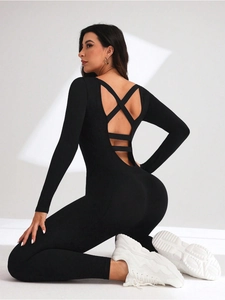 Seamless backless black yoga bodysuit with criss-cross straps and long sleeves
