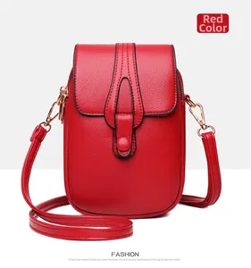 Detail of red textured leather crossbody phone bag with gold hardware and U-shaped stitching