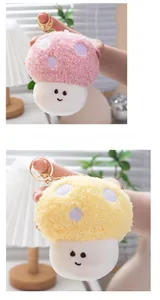 Detail of cute mushroom plush keychains in pink and yellow with embroidered smiles