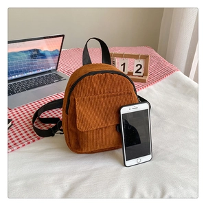 Detail view of mini brown corduroy backpack showing soft texture and front pocket