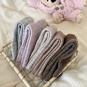 Thick wool gradient crew socks in warm autumn tones organized in a metal basket