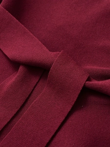 Macro shot of dark red knit fabric texture and elegant tied waist belt detail