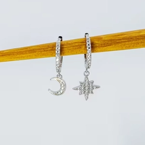 Detailed macro view of S925 sterling silver asymmetrical moon and star stud earrings