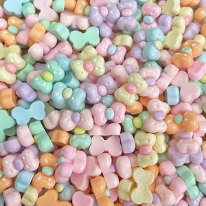 Macro shot of colorful macaron resin bow beads with threading holes for DIY nail art and jewelry