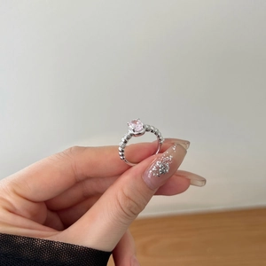 Close-up of S925 silver ring with oval pink zircon and unique beaded band texture