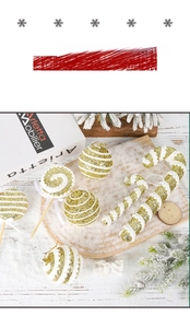 Detailed view of gold glitter Christmas tree ornaments on snow covered wooden base