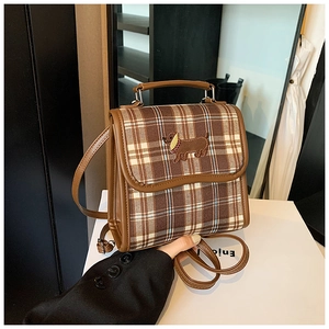 Detail of vintage brown plaid backpack with cute dachshund dog embroidery and PU leather straps