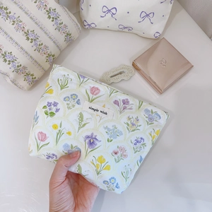 Détail d'une trousse à maquillage florale avec étiquette simple wish et zip fluide