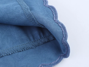 Gros plan détaillé des coutures fines et de l'ourlet sur la robe brodée bleue