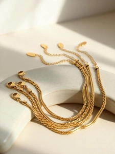 Detail of 18k gold plated stainless steel bracelets with lobster clasp on ceramic display