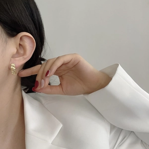 Irregular textured gold earrings in 925 sterling silver worn with white blazer suit