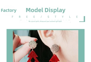 Macro shot of asymmetric red glitter Christmas tree earrings with gold metal base studs
