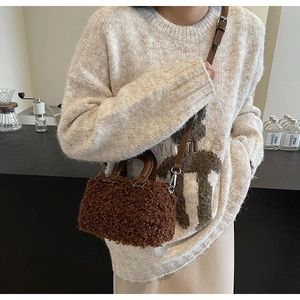 Brown fluffy faux fur crossbody bag with leather handles shown in a cafe setting