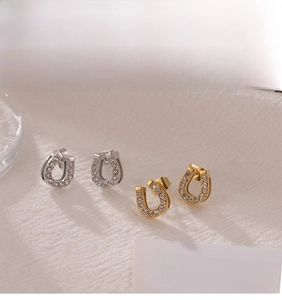 Detailed close-up of U-shaped horseshoe earrings with sparkling white crystals on fabric
