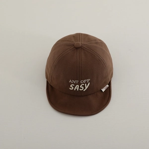 Detailed embroidery of white letters on a brown soft brim baseball cap for infants