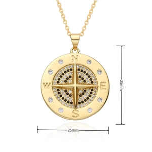 Detailed view of golden compass pendant with black and white cubic zirconia stones