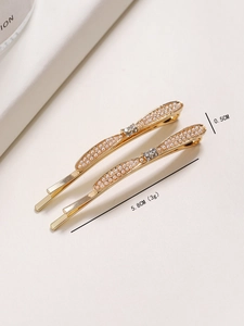 Close-up of golden hair clips with pearls and rhinestones measuring 5.8cm in length