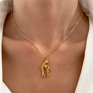 Detailed view of heart necklace with mother and child silhouette on a model's neck