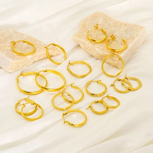 Golden twisted hoop earrings in various sizes and textures on decorative stones