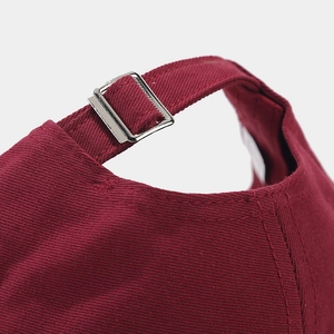 Close-up of wine red cotton baseball cap with adjustable metal buckle and strap