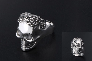 Detailed view of skull ring with intricate floral carvings in polished silver steel