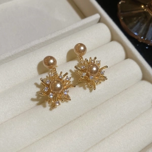 Dettaglio macro degli orecchini a fiore placcati oro 18K con perle e zirconi brillanti