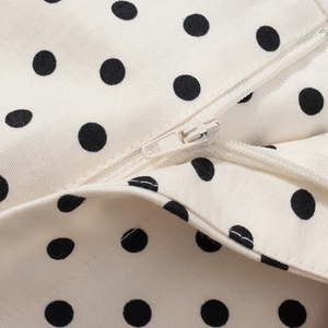 Makroaufnahme von weißem Twill-Stoff mit schwarzen Punkten und verdecktem Reißverschluss