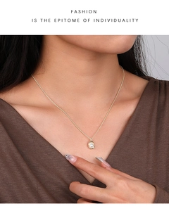 Detail of s925 silver irregular pendant with pearl on a gold chain necklace