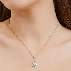 Close-up of a square cut zirconia pendant necklace worn on a woman's collarbone