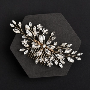 Detail of handcrafted bridal hair comb with gold wires, marquise crystals, and pearls