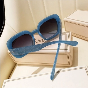 Macro view of blue glitter square sunglasses frame with dark grey gradient lenses