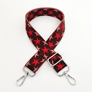 Close-up of star pattern knit bag strap with silver metal lobster clasps and buckle