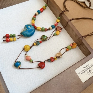 Dettaglio del ciondolo a conchiglia in ceramica artigianale con perline colorate