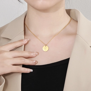 Gros plan du collier en acier doré avec pendentif fleur de naissance sur un mannequin