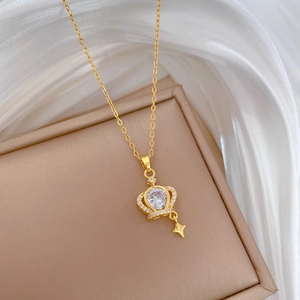 Macro shot of gold crown pendant with sparkling crystals on white silk background