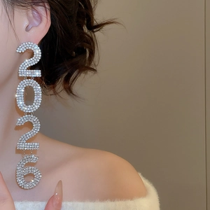 Close-up of dangling 2026 number earrings with silver tassels and sparkling rhinestones