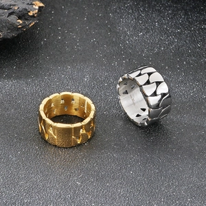 Gold and silver Cuban chain link rings in 316L stainless steel on a textured rock