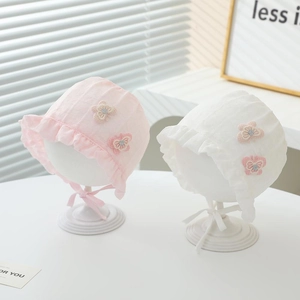 Detail of pink and white lace baby sun hats with butterfly appliques and chin straps