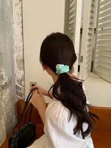 Detail of mint green cotton scrunchie on model ponytail with soft fabric texture