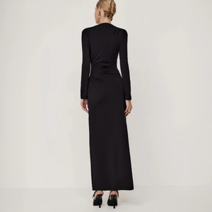 Detail of elegant back ruching and draped fabric on this sleek black maxi dress