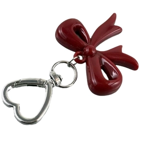Dark red resin bow keychain with silver heart-shaped metal clip on white background