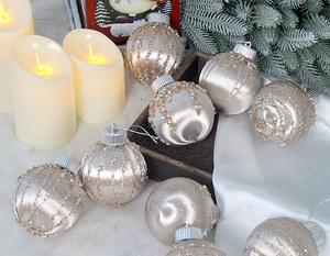 Close-up of champagne gold satin Christmas balls with beads and sequins on a cozy background