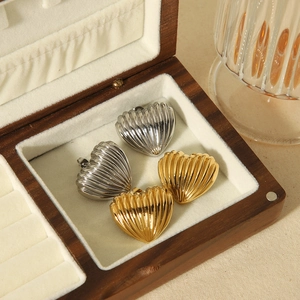 Textured heart-shaped 18k gold and silver stainless steel earrings in a wooden box