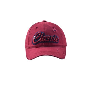 Detail of vintage burgundy baseball cap featuring classic navy embroidery and distressed holes